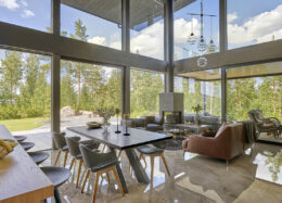 Living room-kitchen of a Polar Life Haus log house with large glass surfaces