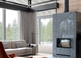 The large glass wall of the Polar log house brings plenty of natural light into the interior